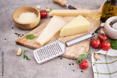 Parmesan cheese and grater on a wooden cutting board