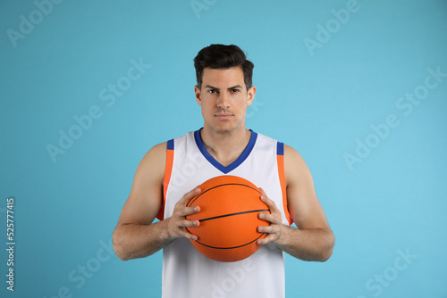Basketball player with ball on light blue background