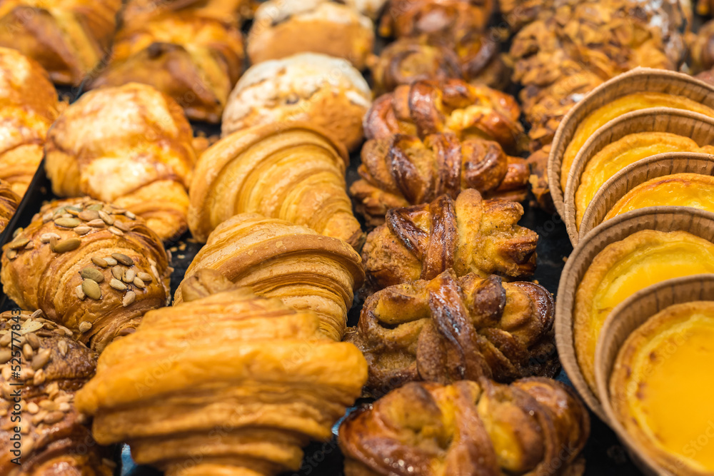 Beautiful delicious croissants and buns, pastry cakes. High-calorie pastries for a snack. Focus with a shallow depth of field. Food background. Beautiful delicious croissants and buns, pastry cakes. High-calorie pastries for a snack. Focus with a shallow depth of field. Food background.