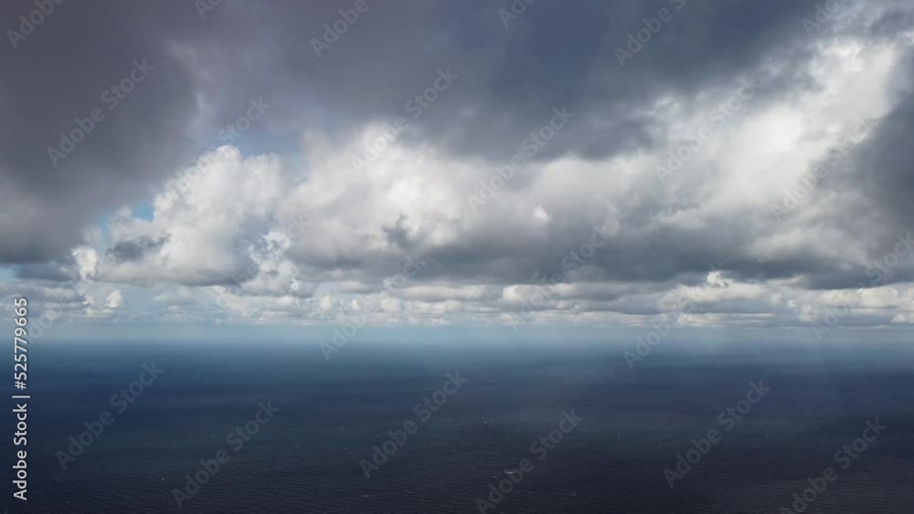 Abstract airy sky with moving plump clouds over the sea ocean. Small waves on clear water surface bokeh lights from sunrise. Holiday, vacation and recreational concept Abstract airy sky with moving plump clouds over the sea ocean. Small waves on clear water surface bokeh lights from sunrise. Holiday, vacation and recreational concept