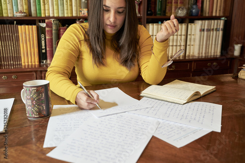 Writer handwriting a novel in an antique library