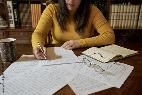 Writer handwriting a novel in an antique library