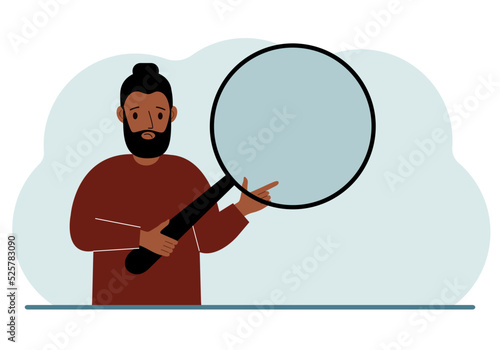 A man holds a large loupe or magnifying glass in his hands.