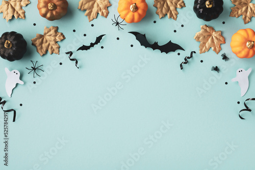 Fotografija Halloween frame with party decorations of pumpkins, bats, ghosts, spiders on blue background from above
