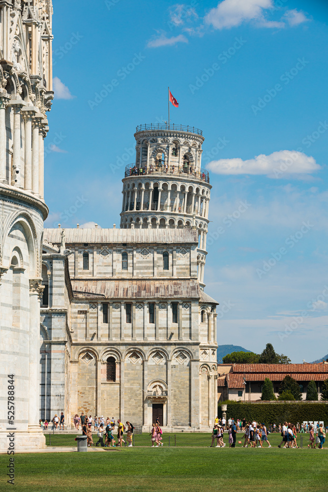 Pisa, Italy - August 8 2022: Leaning Tower of Pisa building on a clear day with white clouds in the sky