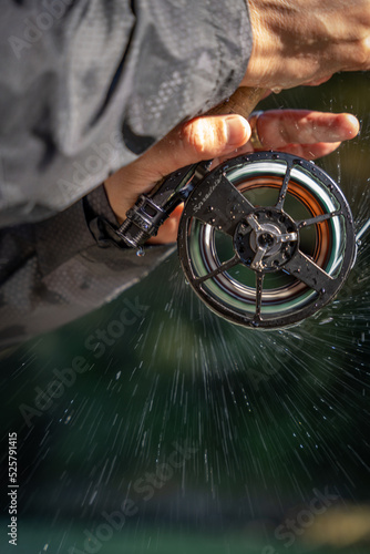 Fly fishing reel with fish on and water spray