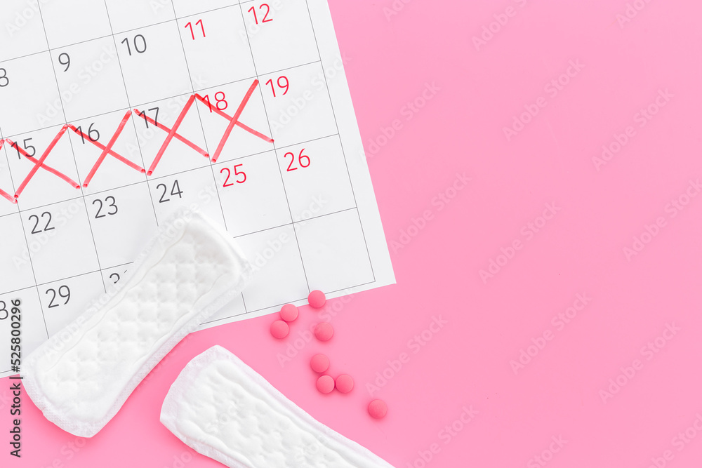 Fototapeta premium Calendar with red marks and white pad. Menstruation period concept