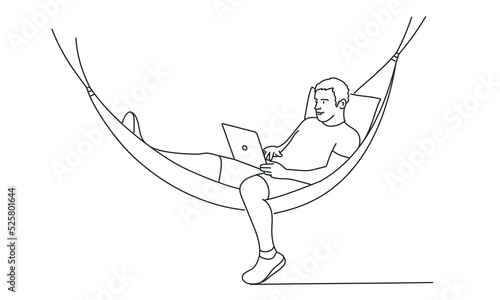 Young man in a hammock working as a freelancer in the distance