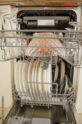 Clean dishes in the new dishwasher in the kitchen. The concept of home interior and comfort