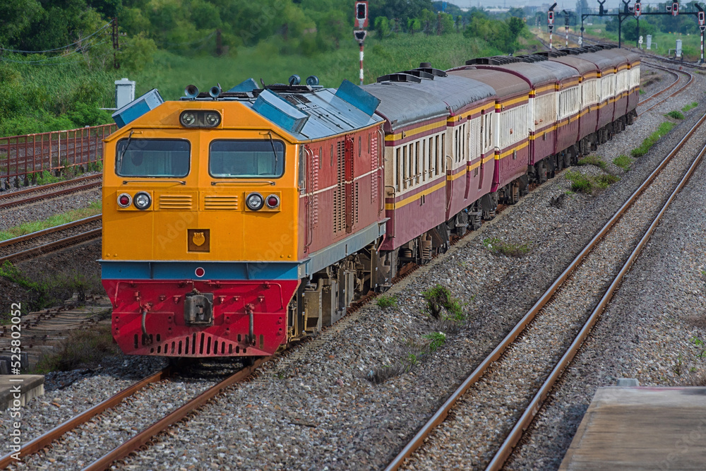 Naklejka premium Passenger train by diesel locomotive on the railway in Thailand.