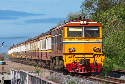 Passenger train by diesel locomotive on the railway in Thailand.