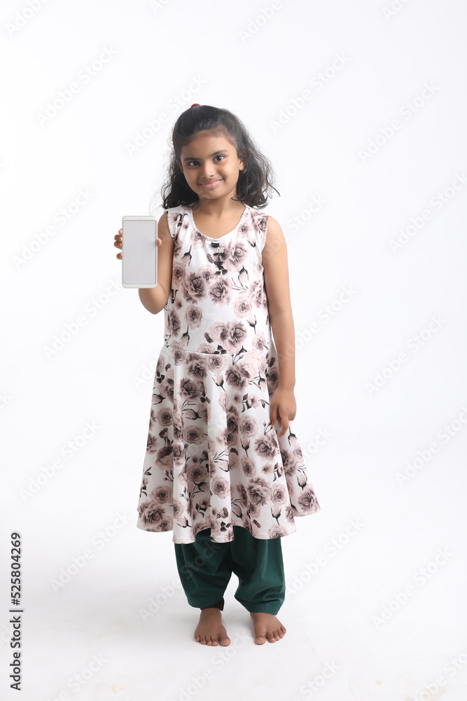 Cute indian little girl showing smartphone on white background. Cute indian little girl showing smartphone on white background.