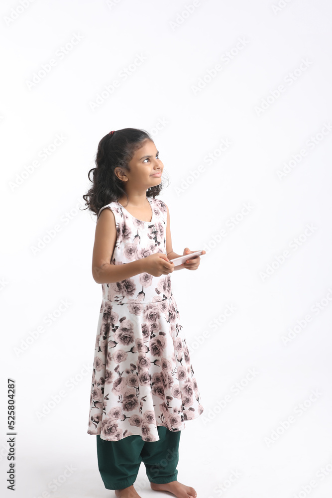 Cute indian little girl using smartphone on white background. Cute indian little girl using smartphone on white background.
