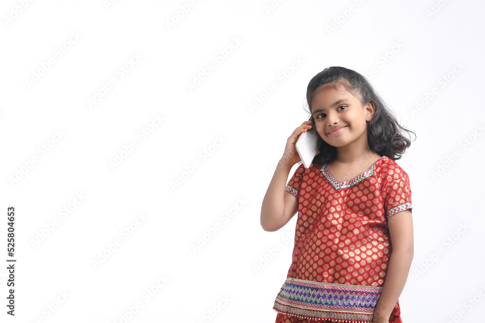 Indian little girl talking on smartphone over white background. Indian little girl talking on smartphone over white background.