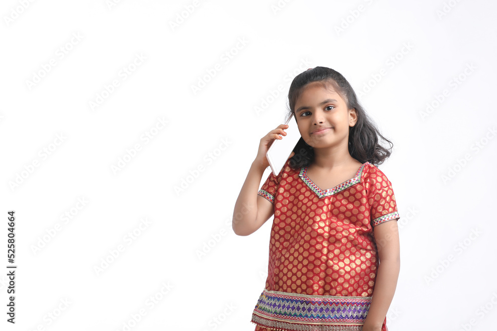 Indian little girl talking on smartphone over white background. Indian little girl talking on smartphone over white background.