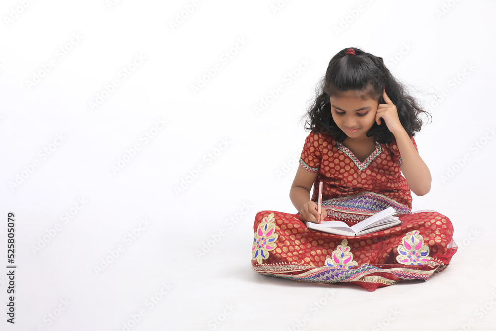 Indian school girl studying on white background. Indian school girl studying on white background.