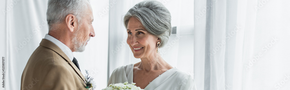 bearded middle aged groom looking at happy bride in white dress, banner bearded middle aged groom looking at happy bride in white dress, banner