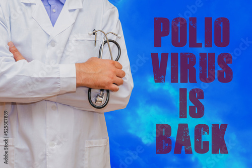 Inscription POLIO VIRUS IS BACK.an unrecognizable doctor stands nearby.detection of poliomyelitis virus.New polio virus infects dozens in USA.Blue dramatic background. photo