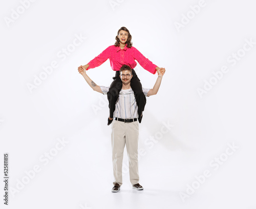 Young man and woman in 50s, 60s fashion style clothes having fun isolated on white background. Retro vintage style, business, ad, emotions