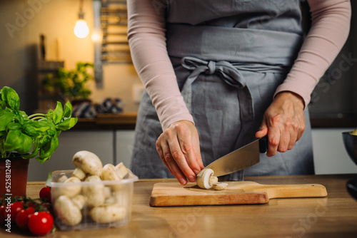 woman chopping mushrooms in kitchen