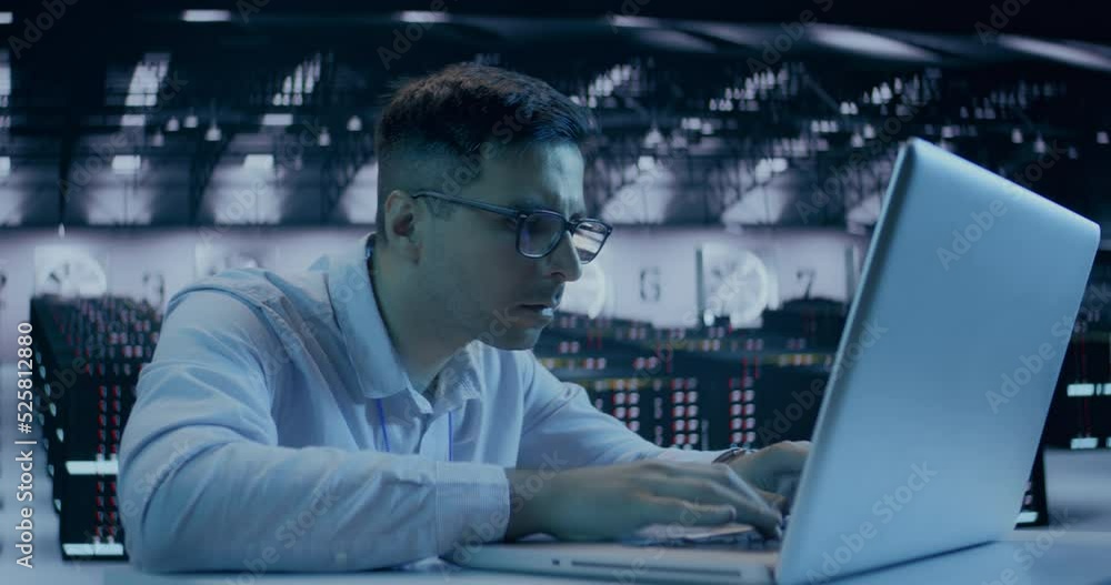 Caucasian male, IT technician using laptop, doing maintenance and diagnostics in the Server Room. Caucasian male, IT technician using laptop, doing maintenance and diagnostics in the Server Room.