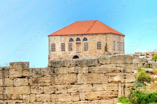 An abandoned traditional Lebanese house in Byblos, Lebanon. View of the colonial architecture with terracotta tile roof and limestone facade. 