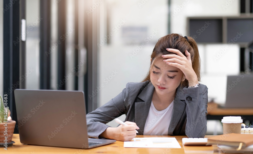 Asian woman who is tired and overthinking from working with a tablet at the office. Asian woman who is tired and overthinking from working with a tablet at the office.