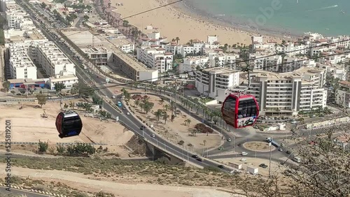 Cable car of the aerial tramway connecting Oufella peak and Agadir city in Morocco, overlooking a panoramic view of the beach. Telepherique cableway ferries passengers up and down the mountain. photo