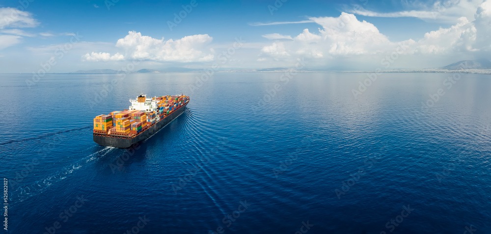 Panoramic aerial view of a industrial cargo container ship traveling over calm, open sea with copy space - obrazy, fototapety, plakaty 