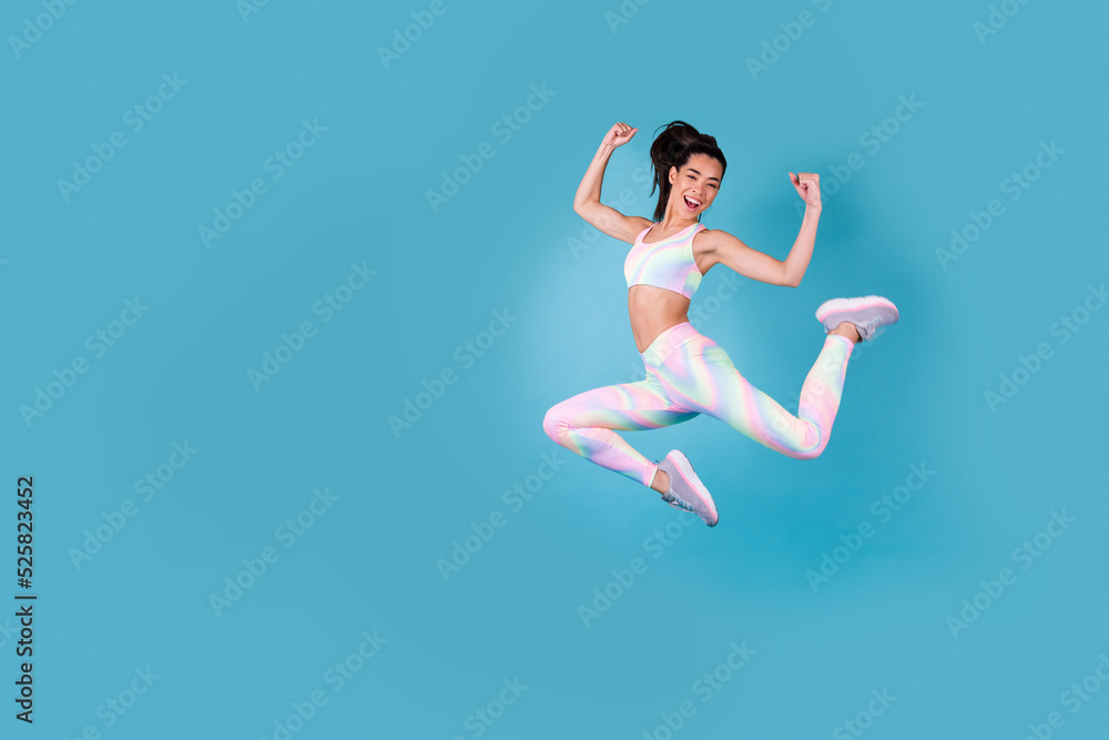 Full length photo of excited chinese girl fists fitness sales banner dressed stylish sporty clothes isolated on vivid blue color background