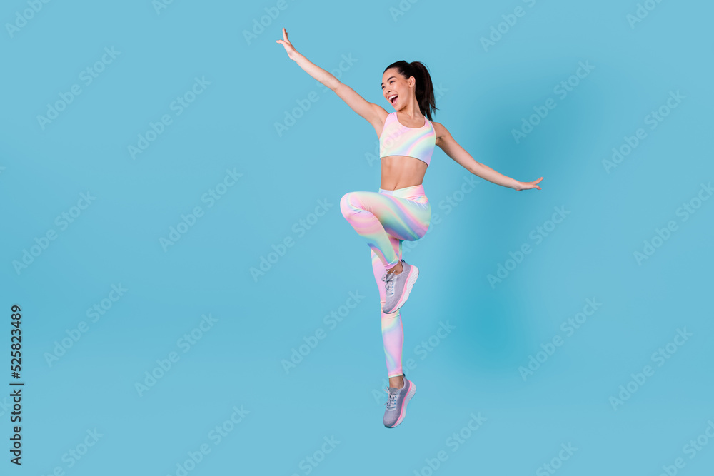 Full size photo of active chinese girl jump pilates shopping discount dressed trendy sporty outfit isolated on vivid blue color background Full size photo of active chinese girl jump pilates shopping discount dressed trendy sporty outfit isolated on vivid blue color background