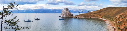 Baikal Lake in August. Panoramic view of famous Shamanka Rock on Olkhon Island - a place of attraction for tourists traveling on sailing yachts on the water and beach lovers. Summer travaling concept