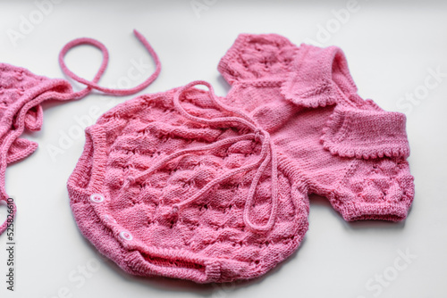 Beautiful baby knitted clothes and a toy for a newborn baby