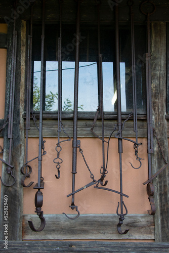 昔の日本家屋の窓の外に吊るされた農具