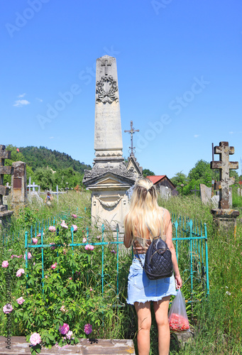 Girl near ancient tombstones near Church of the Nativity of John the Baptist in Kosiv, Ukraine	
 photo