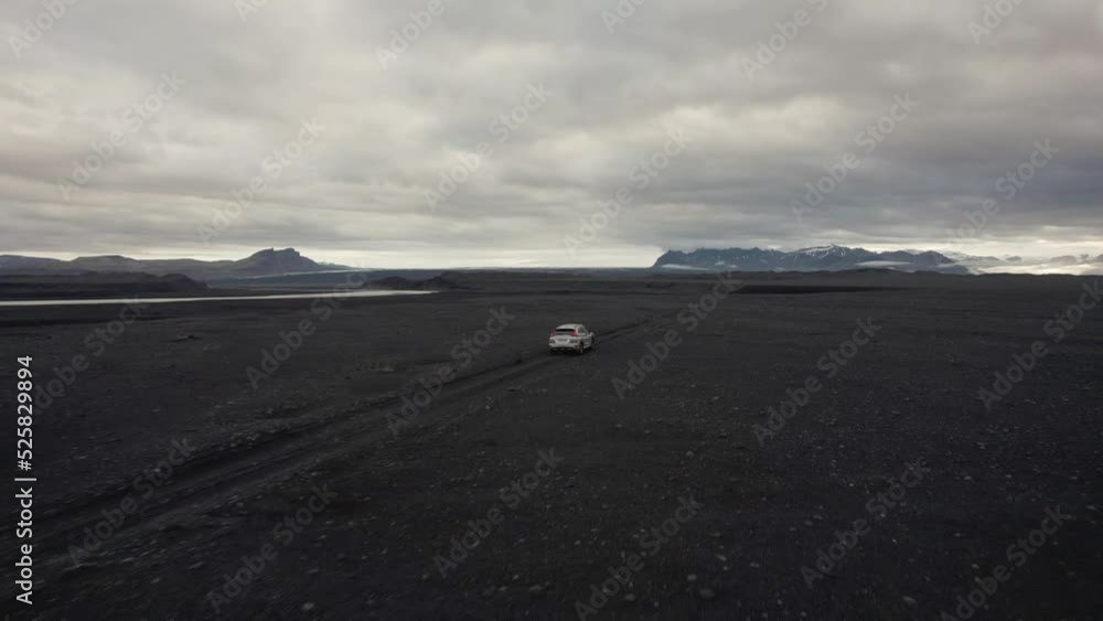 drone following a silver car in a lava field flying upwards with the camera tilting down in Iceland 4k drone following a silver car in a lava field flying upwards with the camera tilting down in Iceland 4k