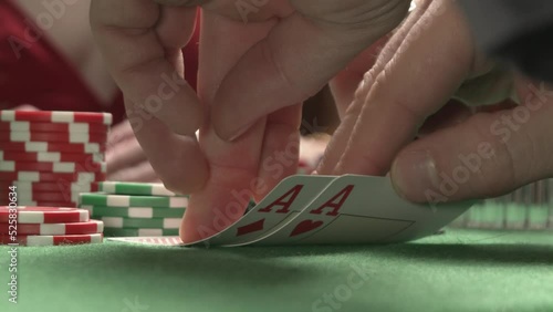 A close-up of checking poker pair of cards. Two red aces. On the background sexy woman player checking her hand. The concept of a possible win, winning a card game, luck, success, all in