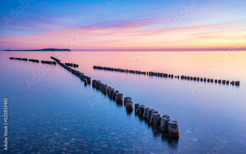 Wooden breakwaters pointing towards the sunset in Dranske  Ruegen  Germany