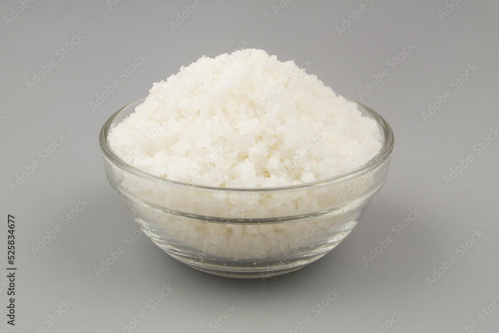 Glass bowl with sea salt on gray background. Glass bowl with sea salt on gray background.