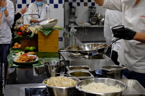 A thai chef cooking a pad thai during a masterclass. Paris, France.