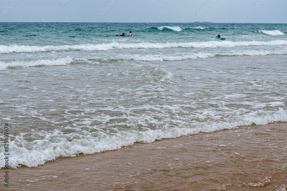 students learning to surf at La Barrosa beach in Sancti Petri, Cadiz, Spain