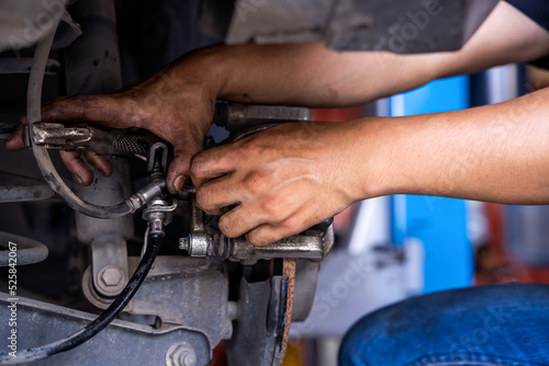 Male car mechanic examining brake disc.Car brake repairing in garage.Selective focus disc brake on car. Car disk brake system service concept
