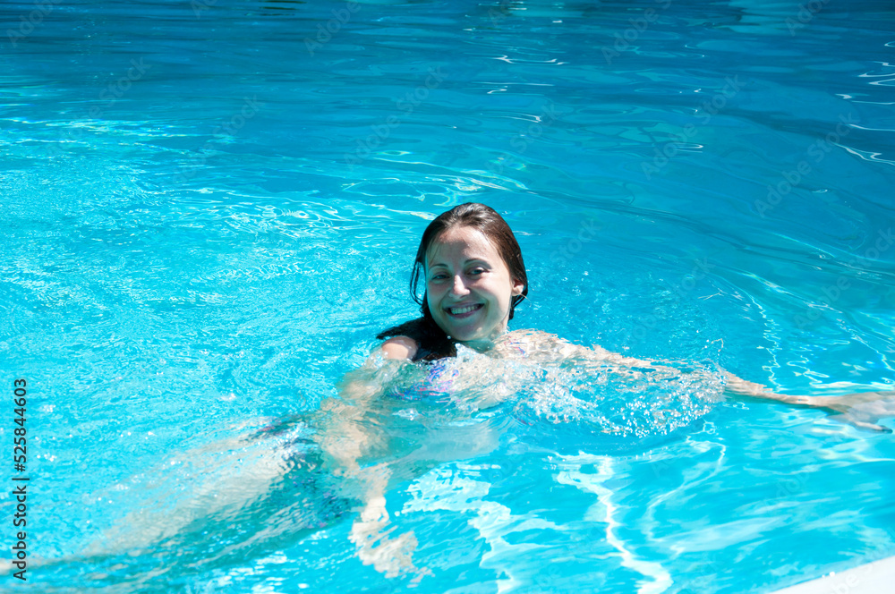 happy woman swimming in summer pool water on vacation