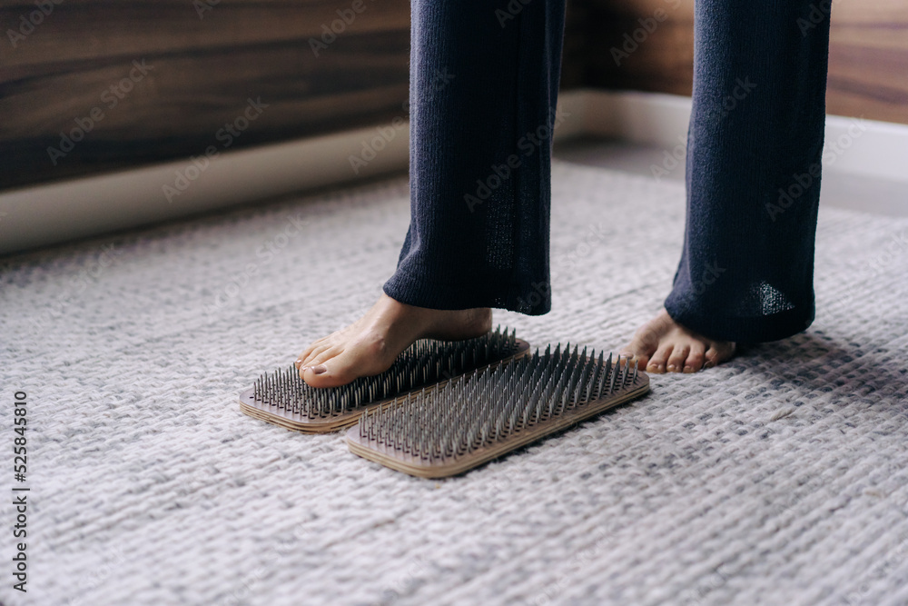 Barefoot female foot stands on a wooden board with nails for concentration practice Barefoot female foot stands on a wooden board with nails for concentration practice