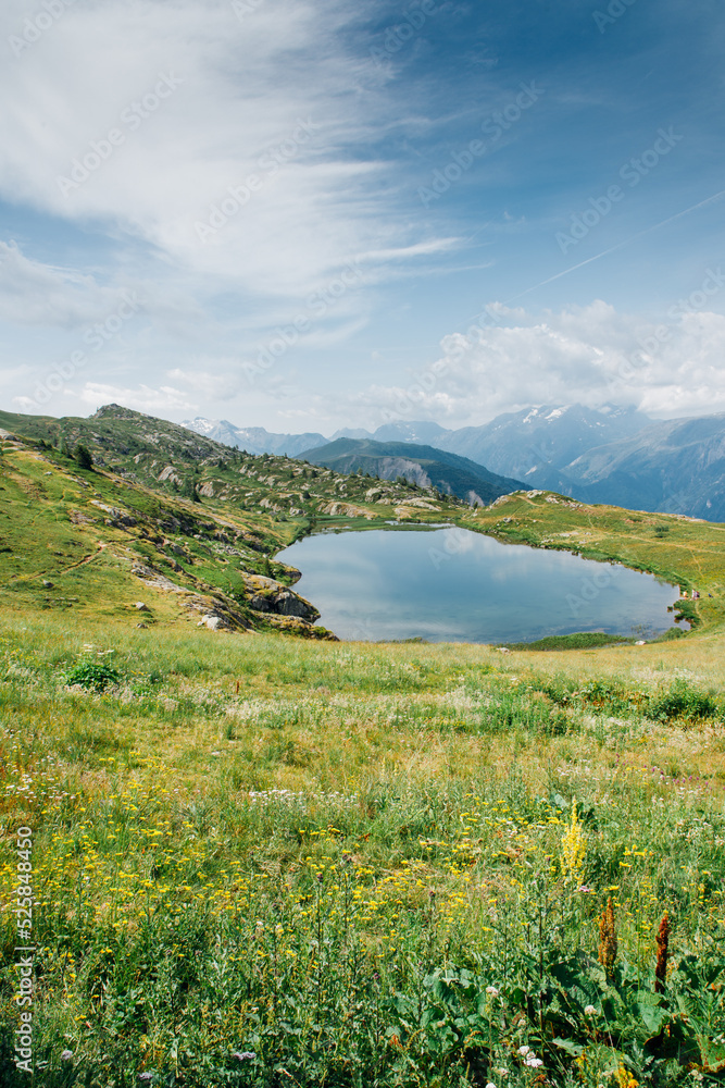 Un lac de montagne. Un petit lac dans les Alpes. Une petite réserve d'eau dans les Alpes. Un petit lac à Vaujany. Une prairie de montagne avec un lac.