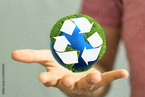 hand holding green recycle symbol