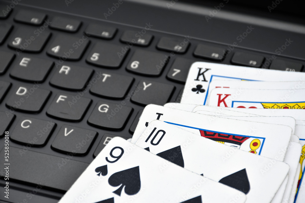 Paper cards on blank laptop keyboard, soft and selective focus, concept for playing cards online with other people at home and recreational activity. Paper cards on blank laptop keyboard, soft and selective focus, concept for playing cards online with other people at home and recreational activity.