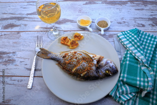 A composition with grilled fish and white wine for dinner.