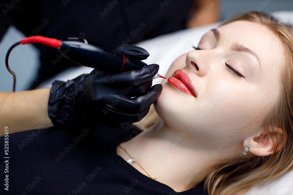 Applying procedure pink pigment permanent tattoo on female lips with tatooing needle machine