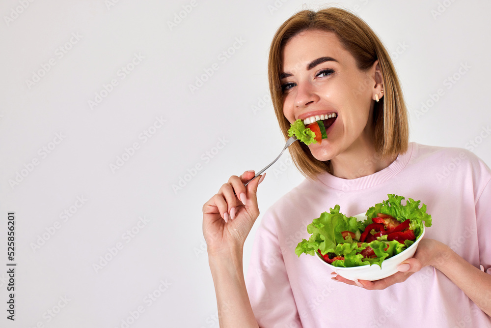 beautiful woman eating fresh vegetable salad on white background beautiful woman eating fresh vegetable salad on white background